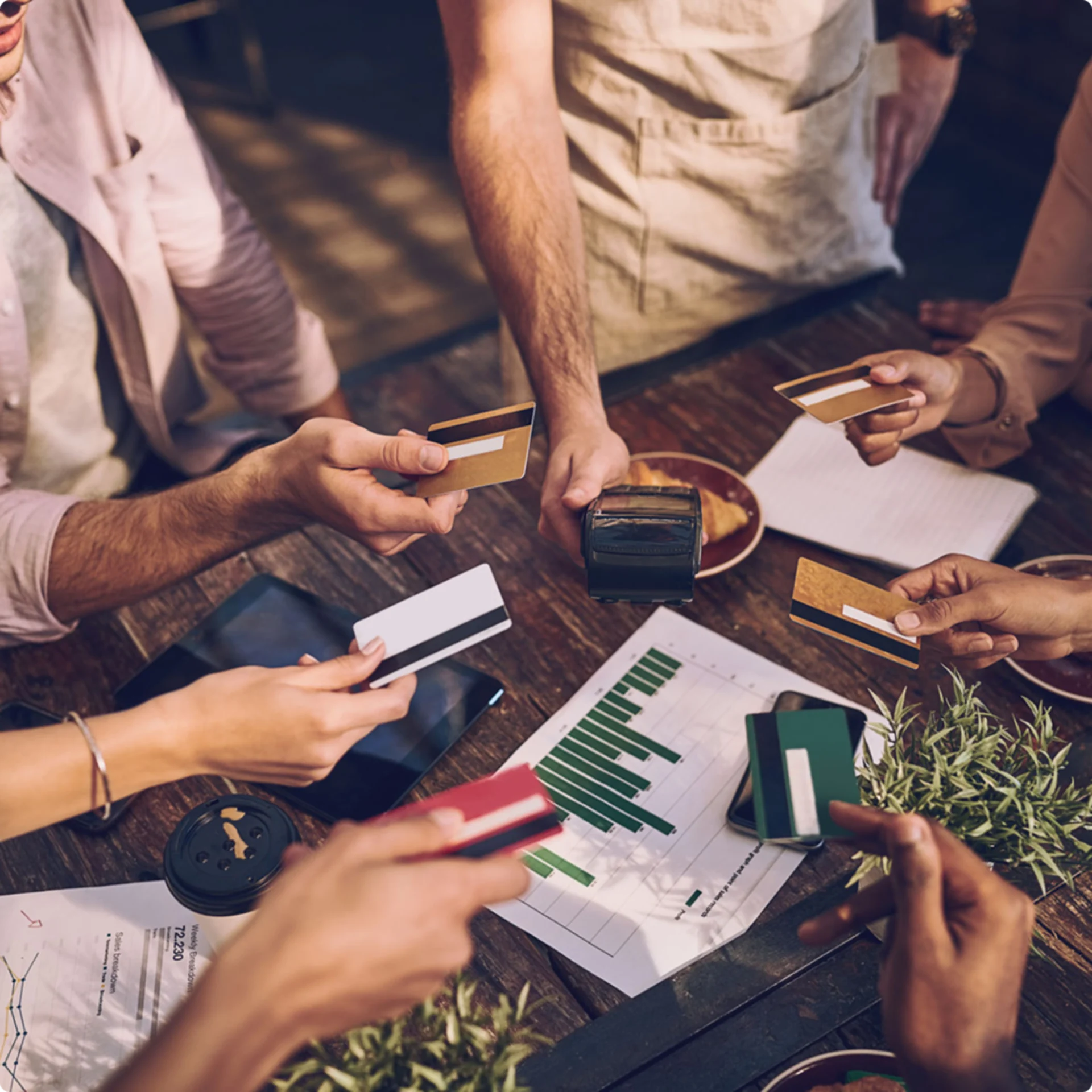 People exchanging credit cards around table